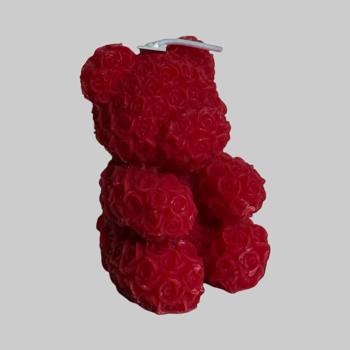 Red rose teddy bear candle with detail floral texture on white background