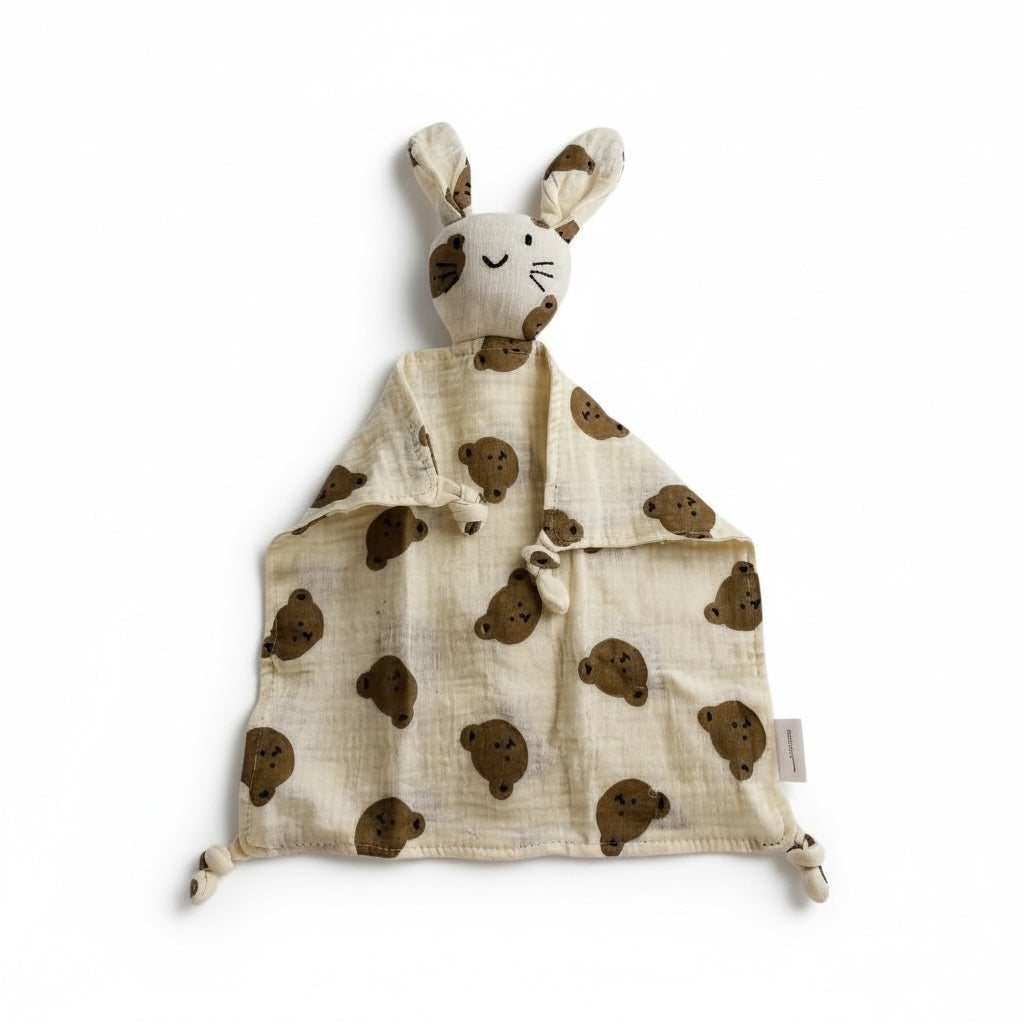 Beige bunny comfort blanket with bunny head brown teddy bear print, made from soft muslin fabric, laid flat on a white background