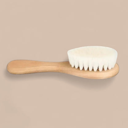 Baby soft wool hair brush with natural wooden handle on neutral background