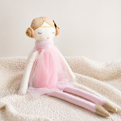 Soft blush fabric doll with tulle dress sitting on a textured neutral blanket, part of premium baby gift hamper, Australia 