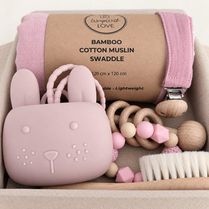 Welcome Baby Hamper in pink with bamboo cotton muslin swaddle, bunny dummy pouch, rattles and wooden baby brush