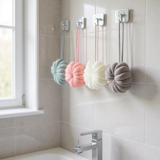 Four colorful bath bombs hanging on hooks in a bathroom.