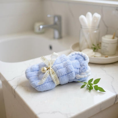 Soft blue mini baby washcloth folded in a cute bunny-ear shape with ribbon and pearl detail, soft newborn washcloth ideal for baby gift hampers