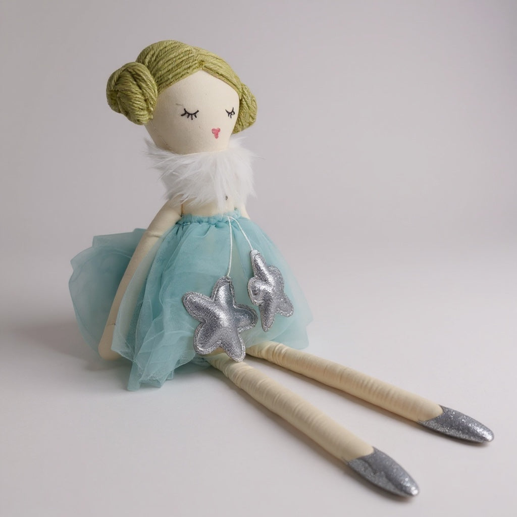 Close-up of soft doll with fabric dress and embroidered facial details