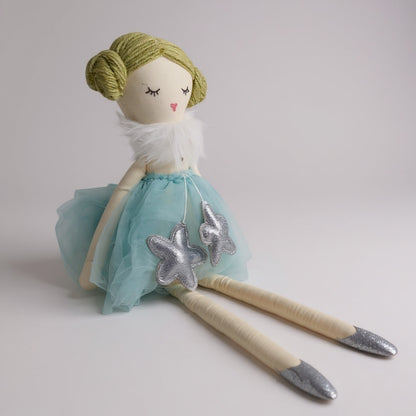 Close-up of soft doll with fabric dress and embroidered facial details