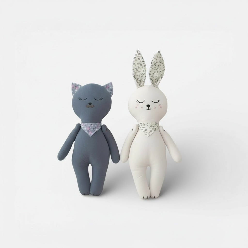 Soft fabric bunny and kitten baby dolls standing side by side on a neutral background