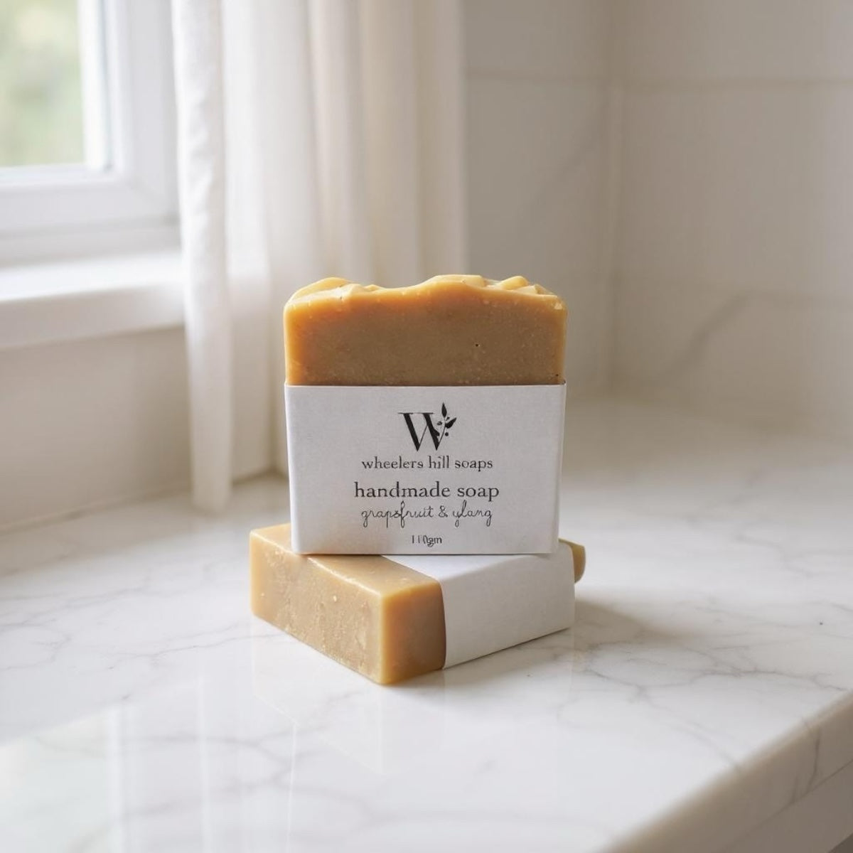 Handmade grapefruit and ylang artisan soap bar on a light marble surface