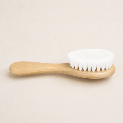 Baby soft wool hair brush with wooden handle on neutral background.