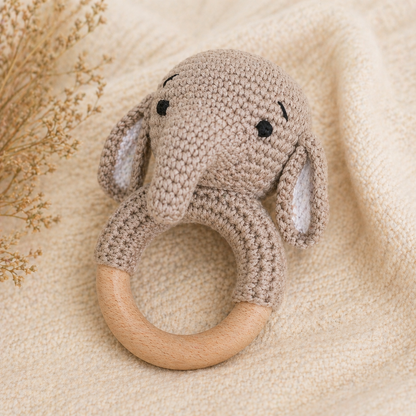 Knitted elephant rattle toy on a soft beige background