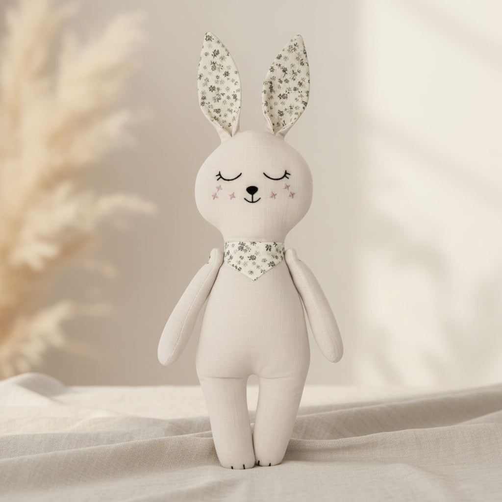 Soft cream bunny baby doll with floral ears and matching neck scarf on a neutral background