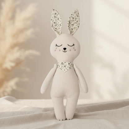 Soft cream bunny baby doll with floral ears and matching neck scarf on a neutral background