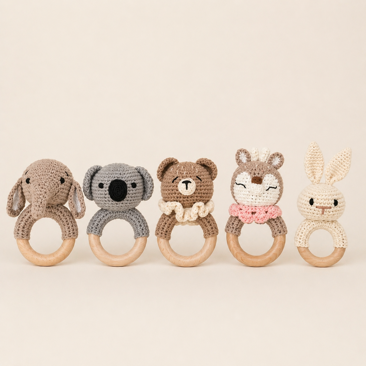 Set of five crocheted animal rattle toys on a beige background