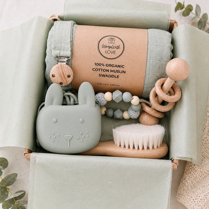 Neutral baby gift box with organic muslin swaddle wooden toys silicone bunny teether ready to gift.