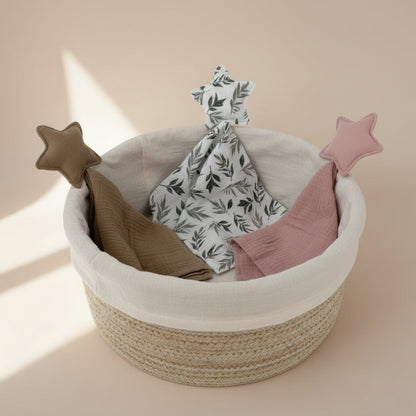 Star shaped cotton muslin comfort blanket in neutral tones displayed in a woven baby gift basket