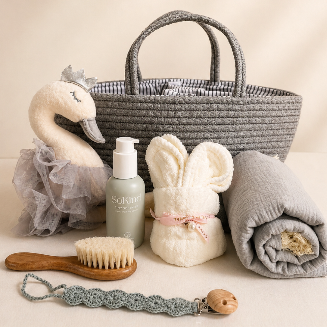 Luxury baby gift basket with swan plush, muslin blanket, bunny towel and SoKind baby lotion in neutral ivory and grey tones